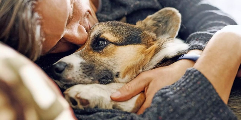 a man cuddling with a dog